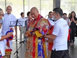 Trance volunteers assist Choje-la in putting on his full oracle regalia in preparation for the trance. 降神仪式助理协助确吉拉穿上降神时的完整服饰。