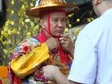 Choje-la puts on the special round travelling hat of Dorje Shugden. 确吉拉戴上多杰雄登护法特殊的圆顶帽。